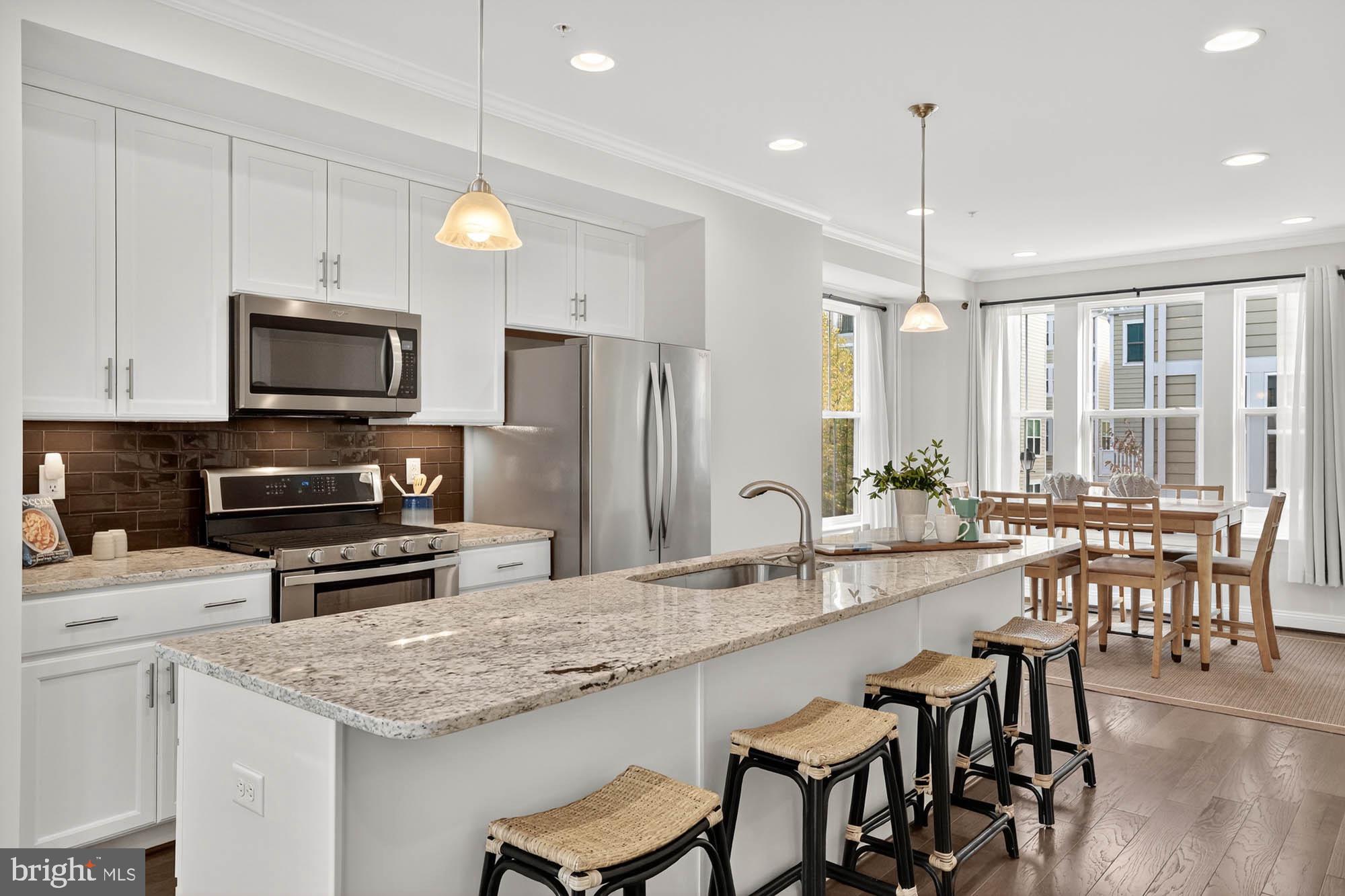 606 James Walker Place Annapolis, MD 21401 - Photo 18 of 52 a kitchen with stainless steel appliances granite countertop a stove a refrigerator a kitchen island a sink and chairs