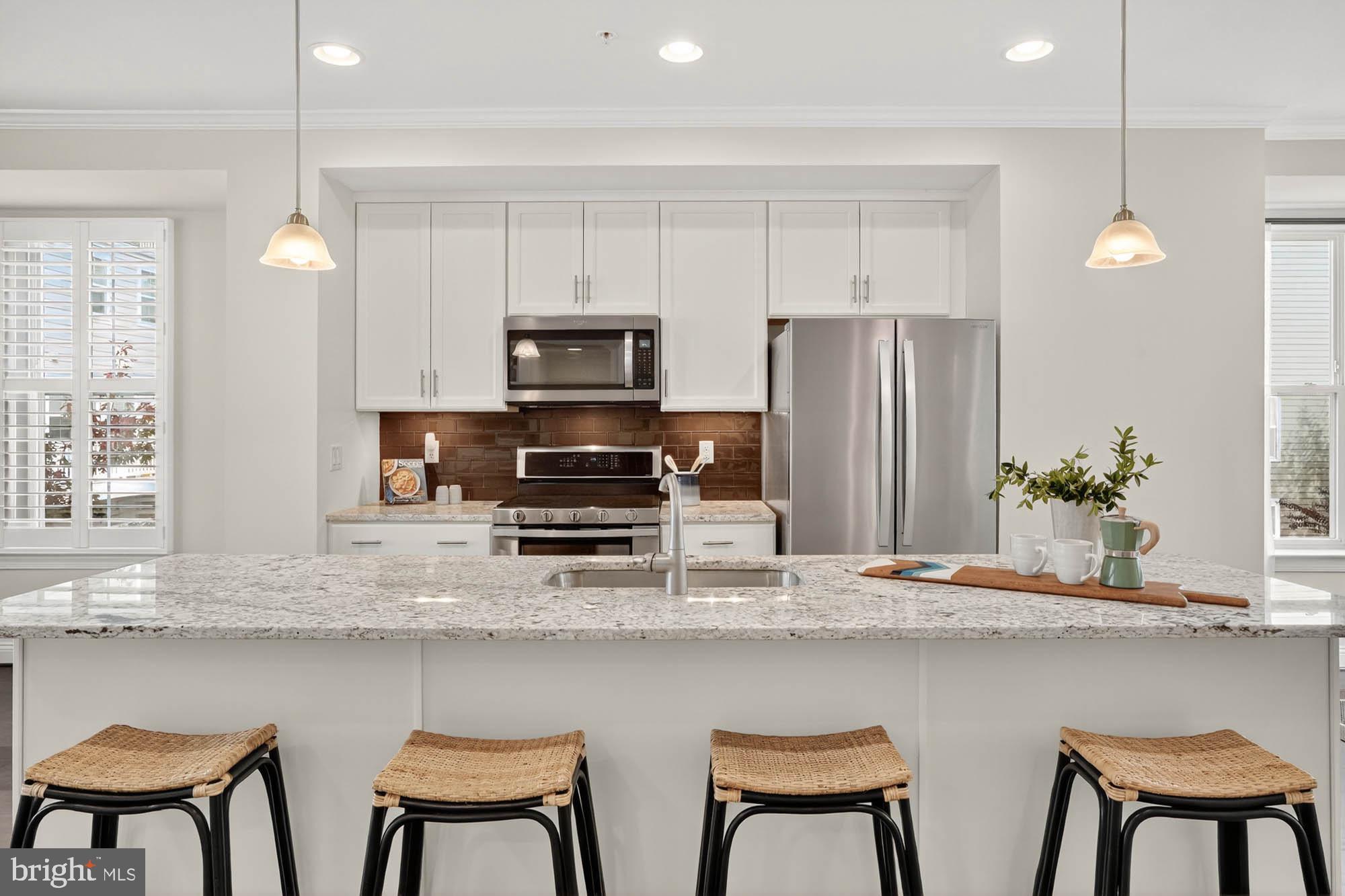 606 James Walker Place Annapolis, MD 21401 - Photo 19 of 52 a kitchen with stainless steel appliances a dining table chairs refrigerator and microwave