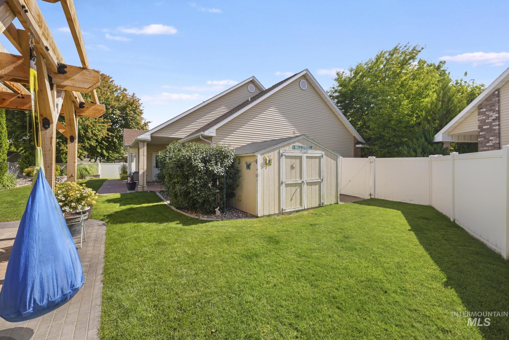 467 Wildrose Loop Twin Falls, ID 83301 - Photo 39 of 46 Expansive backyard featuring a manicured lawn, a large wood pergola, a paved patio, and a white privacy fence