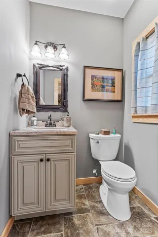 a bathroom with a toilet a sink and mirror