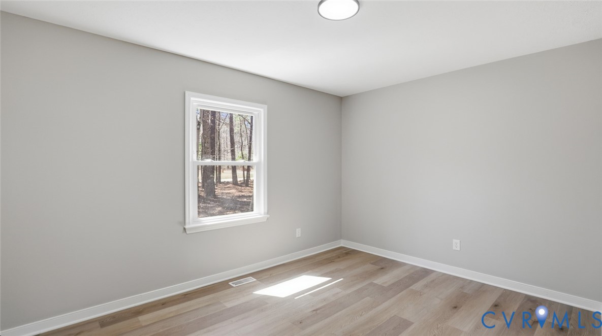 3200 Portugee Road Sandston, VA 23150 - Photo 21 of 26 a view of an empty room with wooden floor and a window