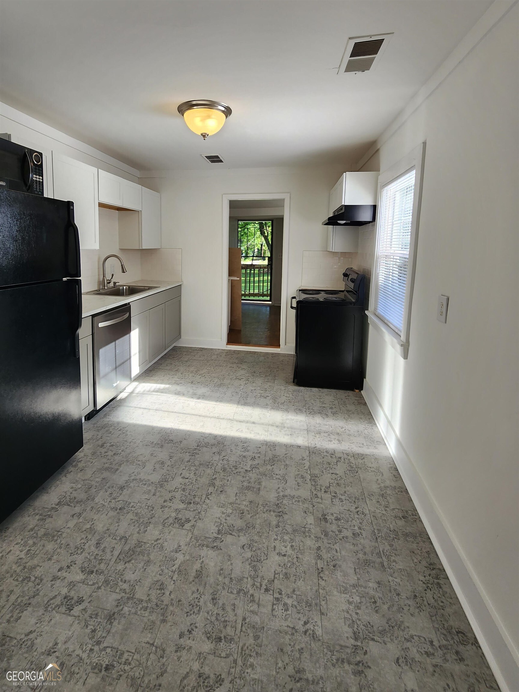 2577 Eastwood Drive Decatur, GA 30032 - Photo 6 of 21 a view of a kitchen with a sink and a refrigerator