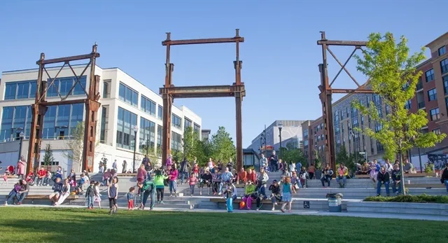 a group of people sitting on a yard in front of a building