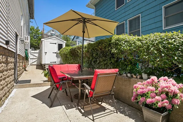 a patio with a table and chairs under an umbrella