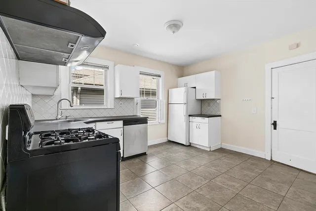 a kitchen with a stove a refrigerator and cabinets