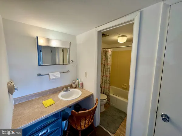 a bathroom with a sink mirror and a toilet