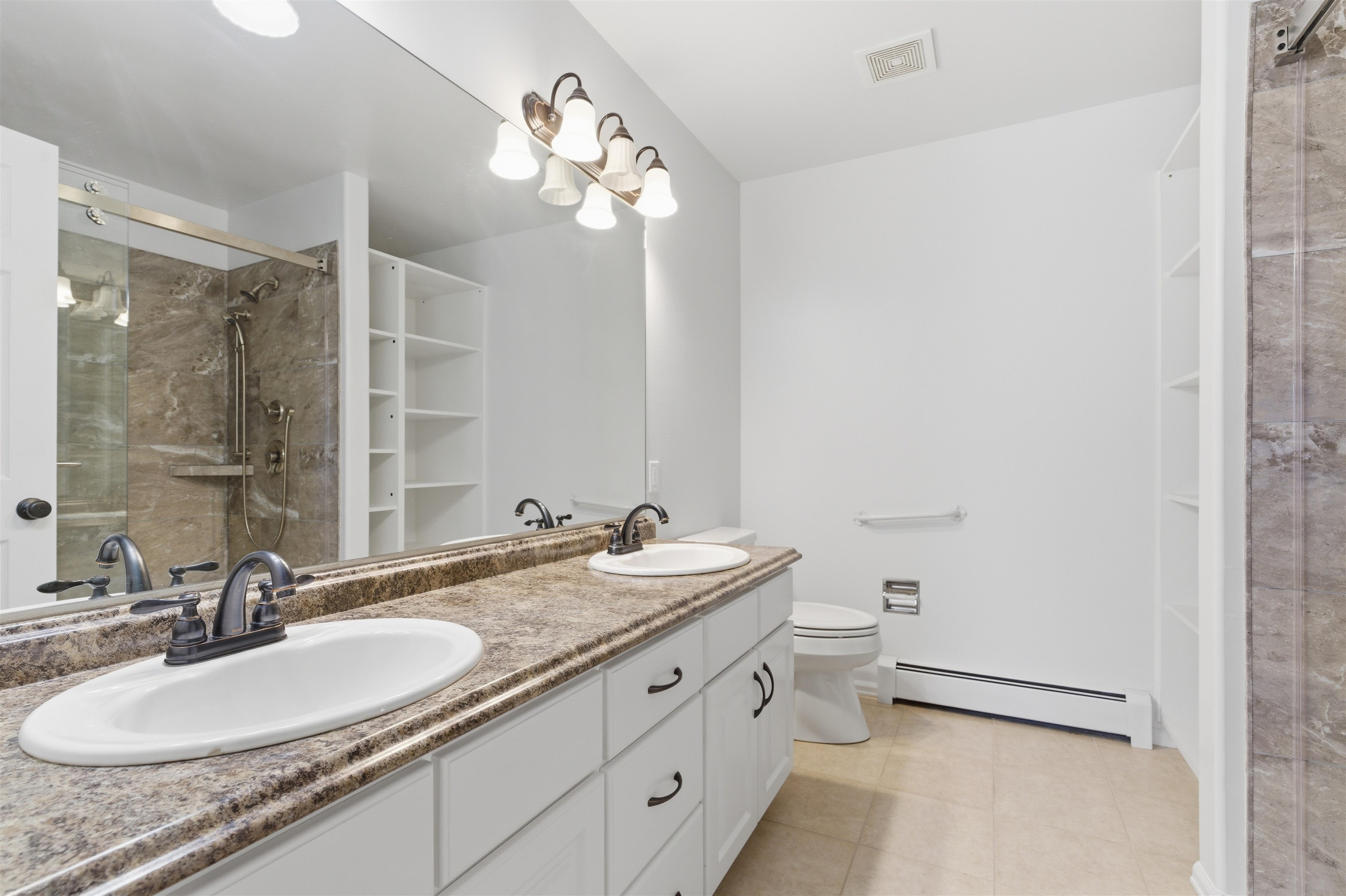 1820 Bittern Court Grand Junction, CO 81506 - Photo 13 of 28 a bathroom with a granite countertop sink a toilet a mirror and shower