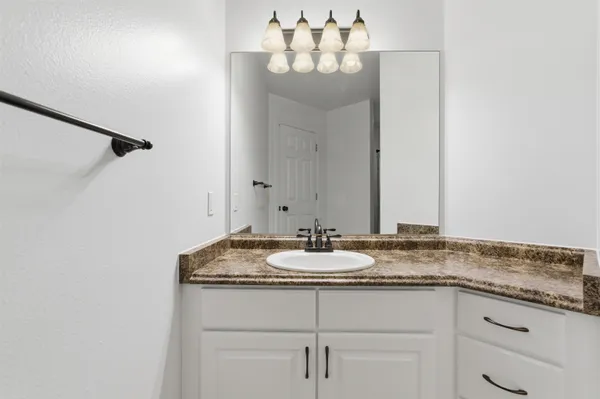 a bathroom with a granite countertop sink and a mirror