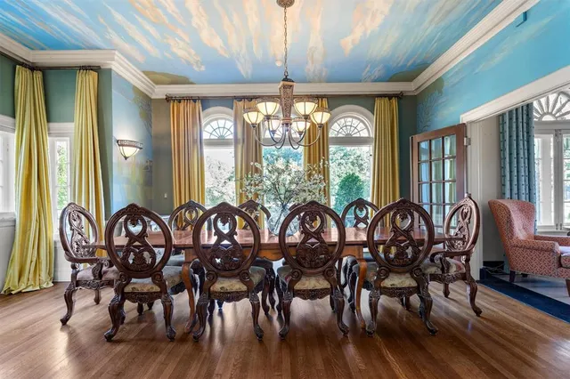 a kitchen with a dining table chairs and large windows