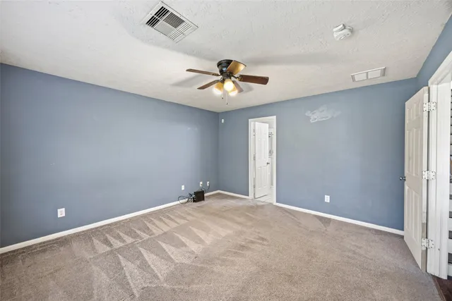 a view of a big room with a ceiling fan and a window