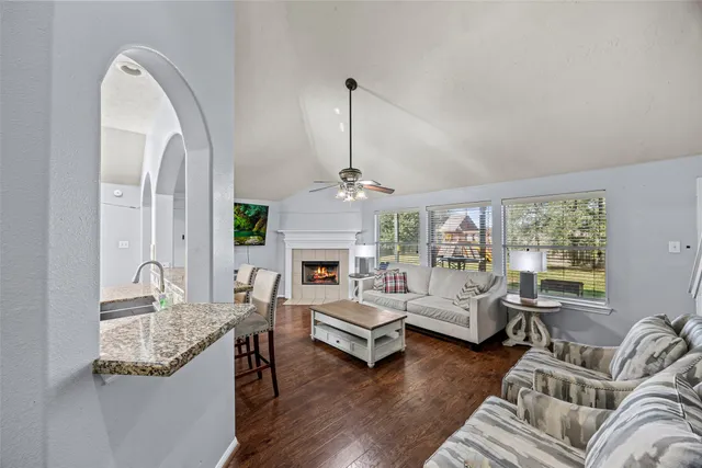 a living room with furniture a fireplace and a chandelier