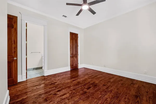 a view of an empty room with a window and a ceiling fan