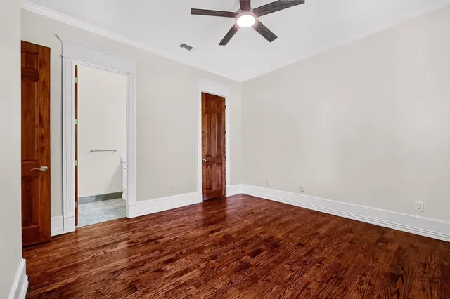 a view of an empty room with a window and a ceiling fan