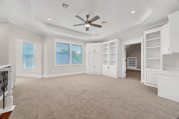 an empty room with a window and a fan