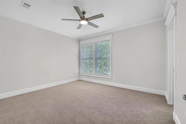 an empty room with a window and a ceiling fan