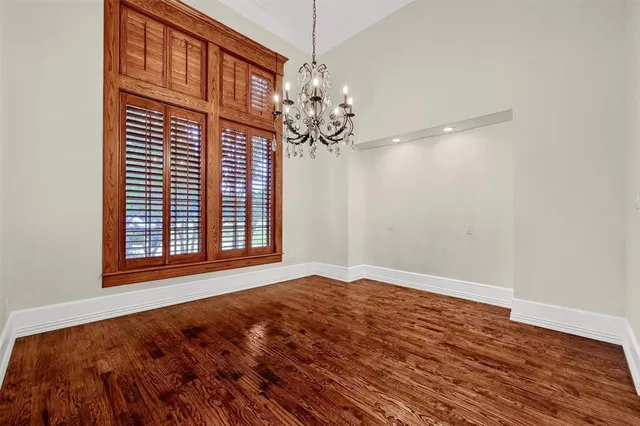 a view of empty room with wooden floor and fireplace