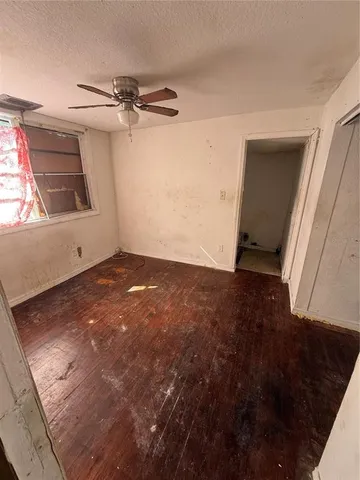 a view of a big room with wooden floor and windows