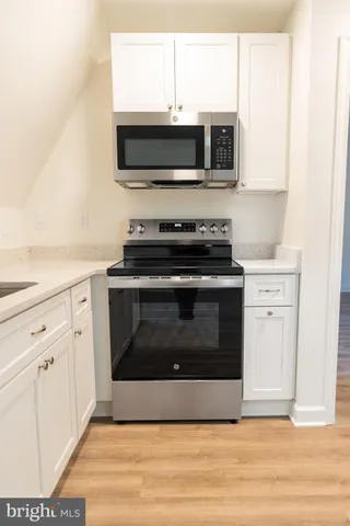 a kitchen with stainless steel appliances a stove a microwave oven cabinets and a sink