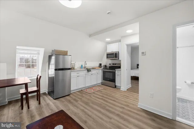 a kitchen with white cabinets and stainless steel appliances