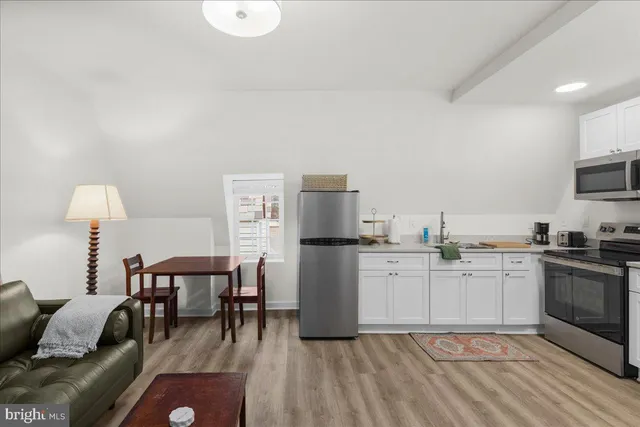 a kitchen with a white cabinets and chairs