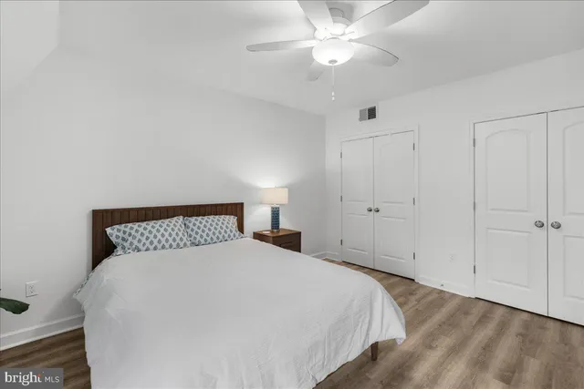 a bedroom with a large bed and a ceiling fan