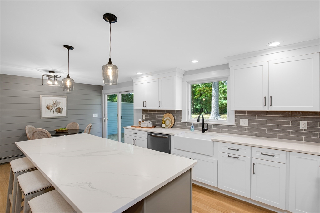 39 Middle Road, Unit A Newbury, MA 01951 - Photo 2 of 40 a kitchen with a stove a sink a center island a cabinets and wooden floor