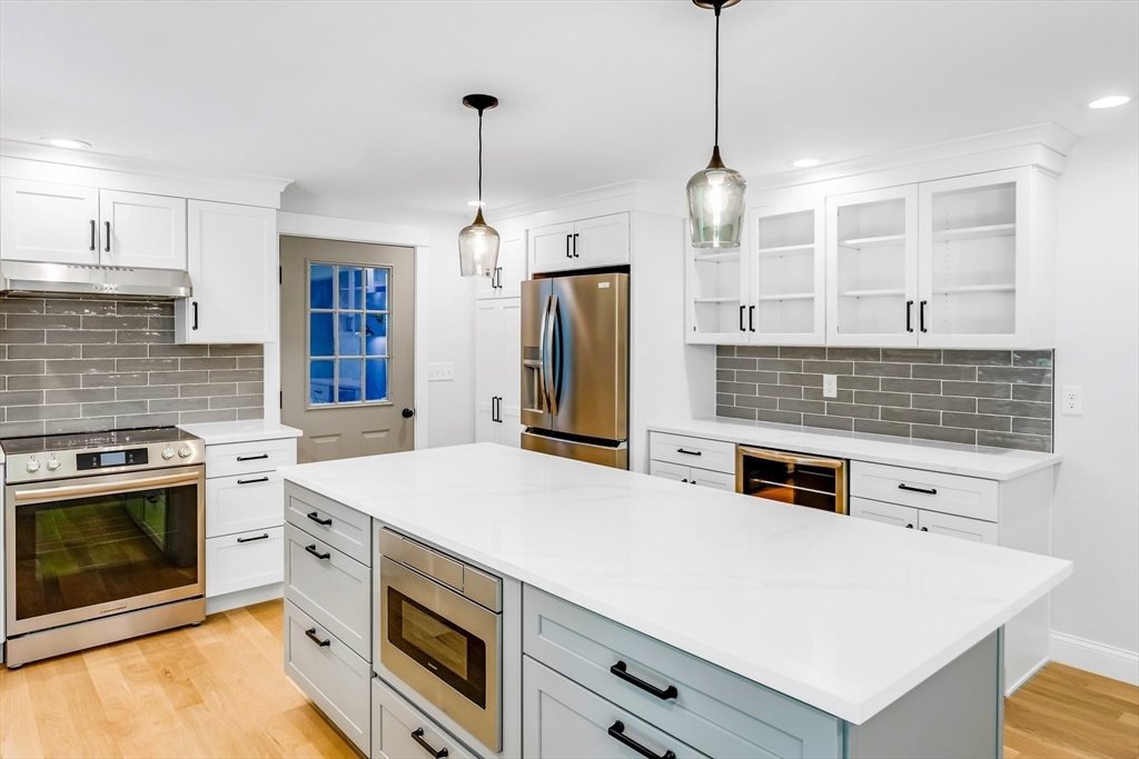 39 Middle Road, Unit A Newbury, MA 01951 - Photo 25 of 40 a kitchen with stainless steel appliances a stove a sink and a wooden floor