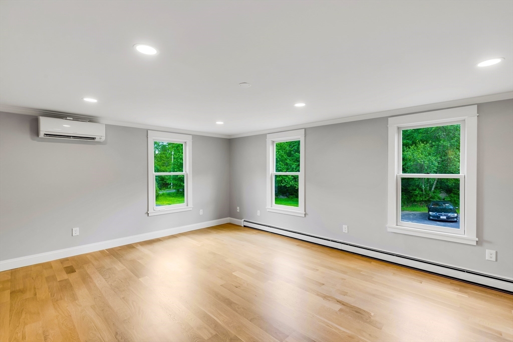 39 Middle Road, Unit A Newbury, MA 01951 - Photo 28 of 40 a view of an empty room with a window and wooden floor