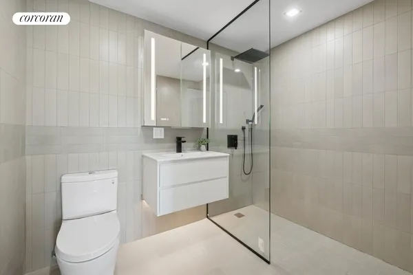 a bathroom with a toilet a sink a mirror and vanity