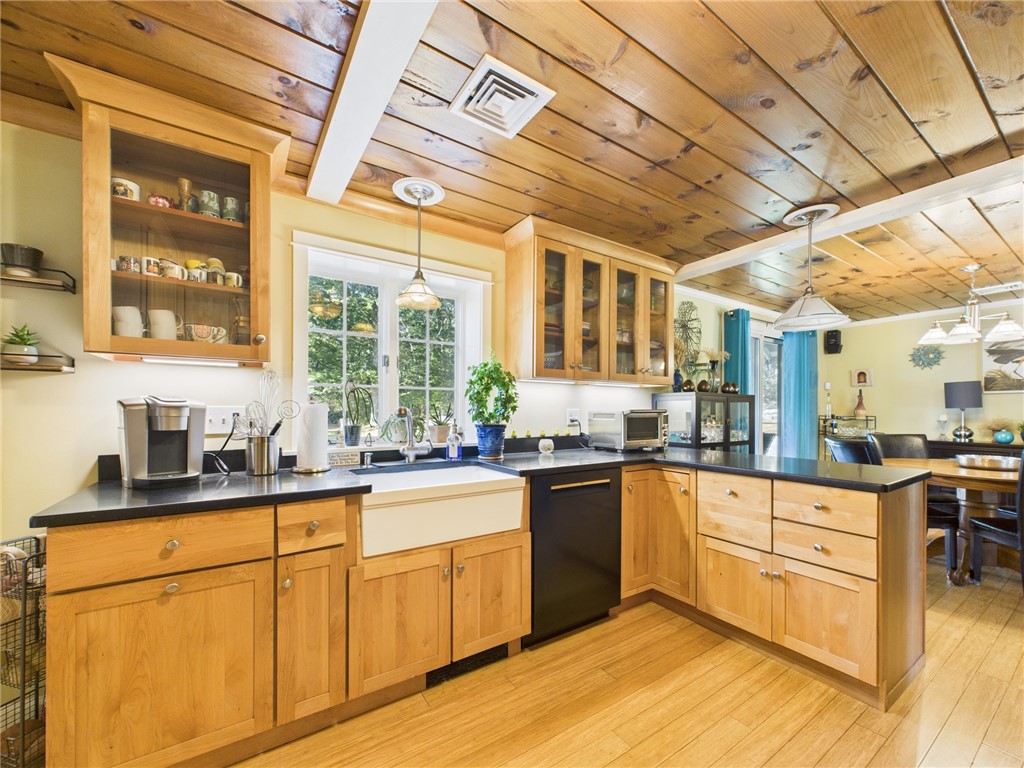 95 Mail Road Exeter, RI 02822 - Photo 12 of 33 Gorgeous state-of-the art designer chef's kitchen. The cabinetry is solid birch topped with black matte granite counters. You'll awe at the striking blend of woods; & the sand and black color scheme carries thru from the LR to this room. View from the double hung window at the farmer sink is special.