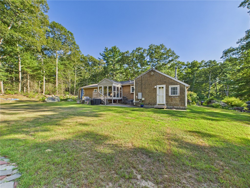 95 Mail Road Exeter, RI 02822 - Photo 30 of 33 Showing a rear view of the home and the expanse of the tree lined, private yard. The driveway can accommodate all the guests and has a convenient branch off 'turn around" and alternate exit.