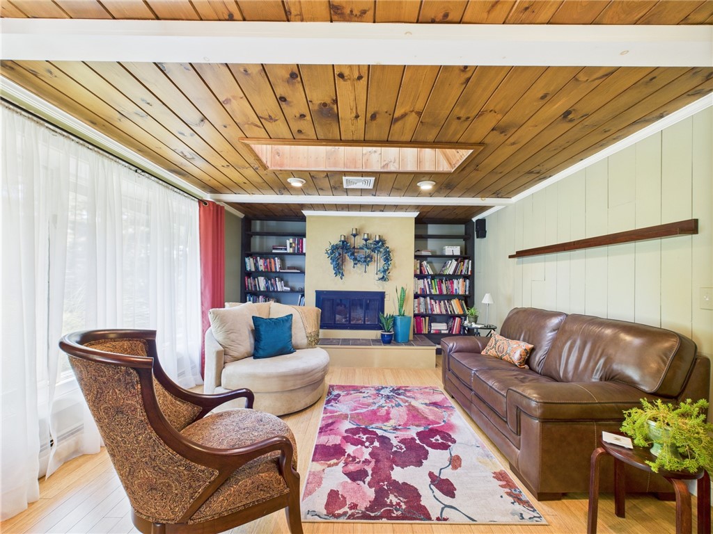 95 Mail Road Exeter, RI 02822 - Photo 4 of 33 To the left of the entry is this gorgeous living room w/solid polished pine ceilings dotted w/recessed lights drawing one to the woodburning FP with stucco surround, complemented by floor to ceiling black bookcases. The bamboo flooring adds to the drama and warmth of this room and carries through the home.