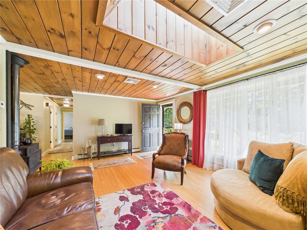 95 Mail Road Exeter, RI 02822 - Photo 6 of 33 Looking out to the entry hall and a glimpse of the front door to the far right. The ceilings throughout the main living area add to the warmth of this distinctive home. Also, note the skylight, lined w/ polished pine.