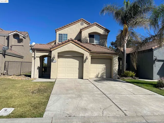 a front view of a house with yard and tress