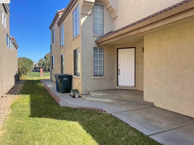 a view of a house with backyard and sitting area