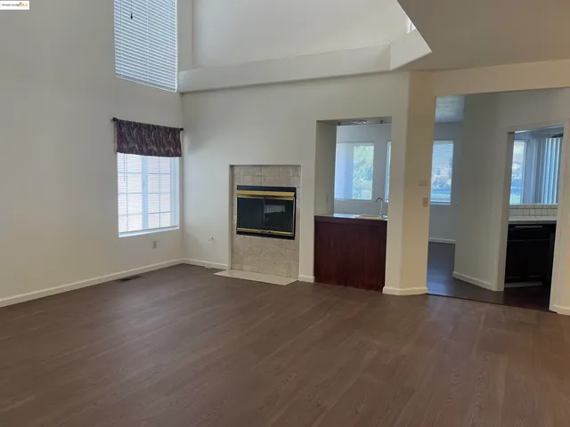 an empty room with windows and a fireplace