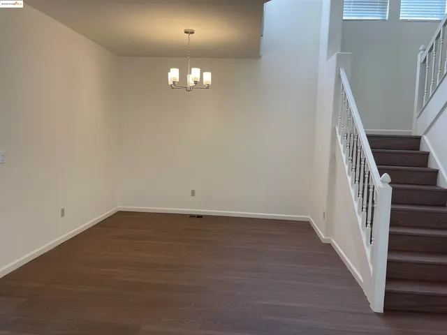 an empty room with wooden floor and stairs