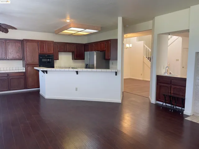 a view of kitchen with wooden floor and electronic appliances