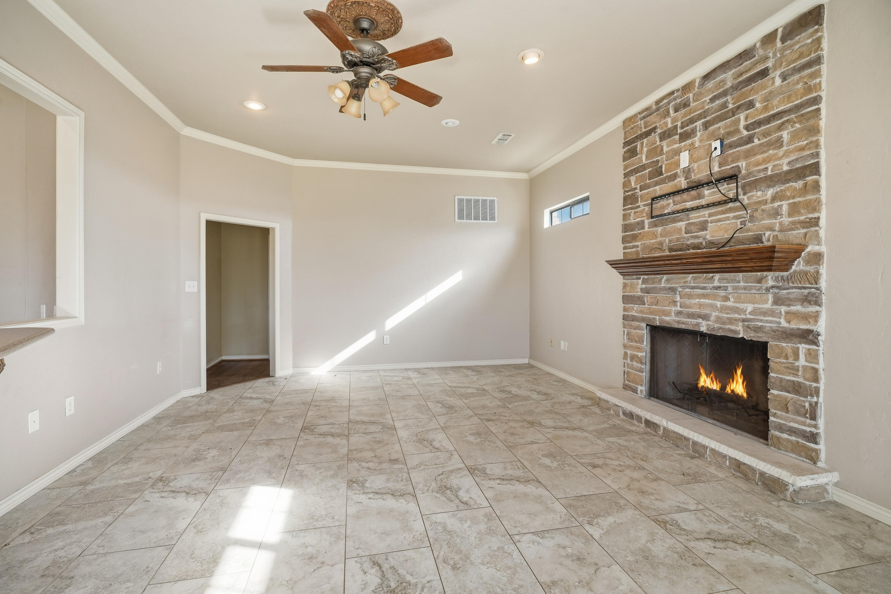 5601 County Road 7920 Lubbock, TX 79424 - Photo 14 of 68 a view of an empty room with a fireplace and a ceiling fan