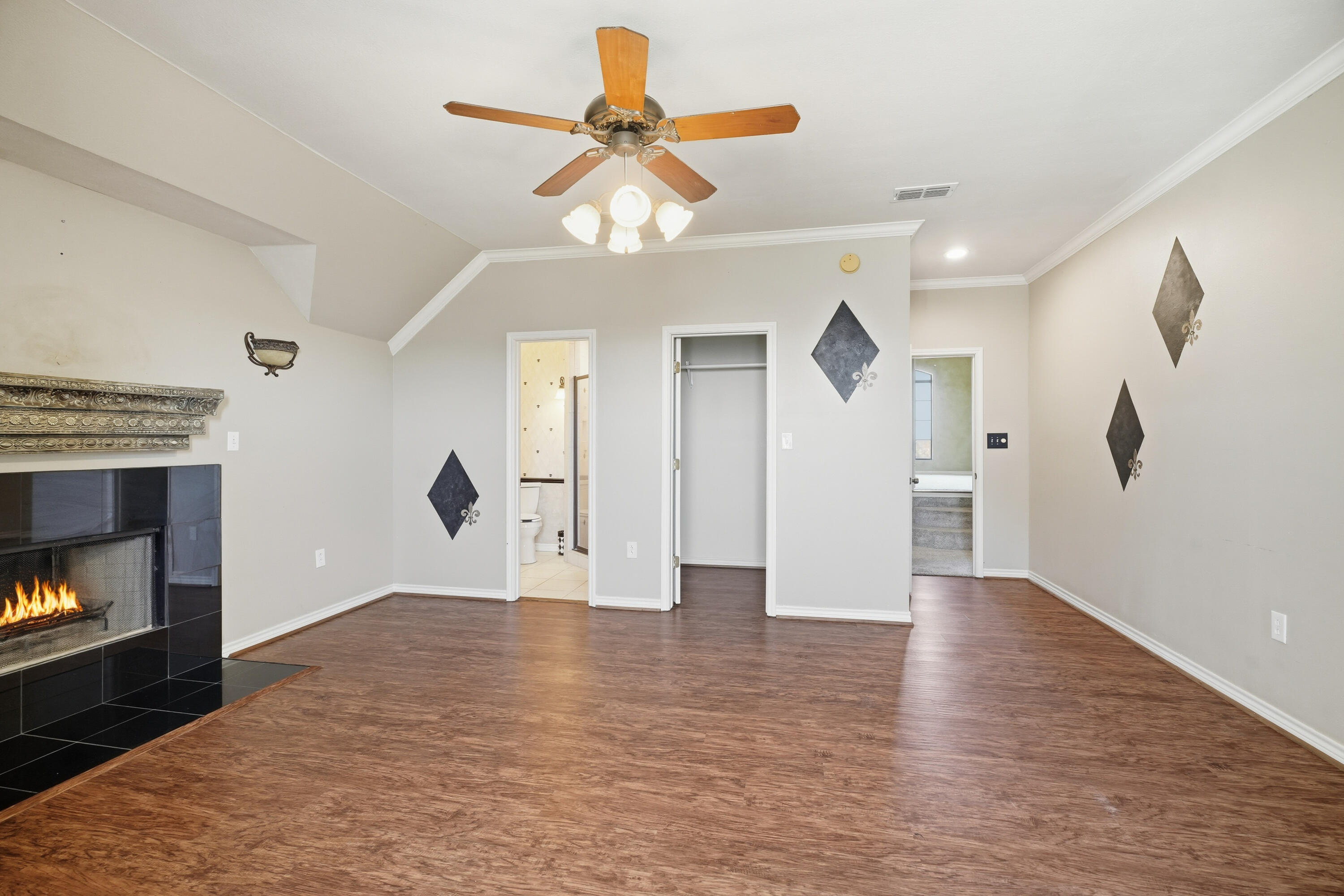 5601 County Road 7920 Lubbock, TX 79424 - Photo 39 of 68 a view of an empty room with wooden floor a fireplace and a ceiling fan