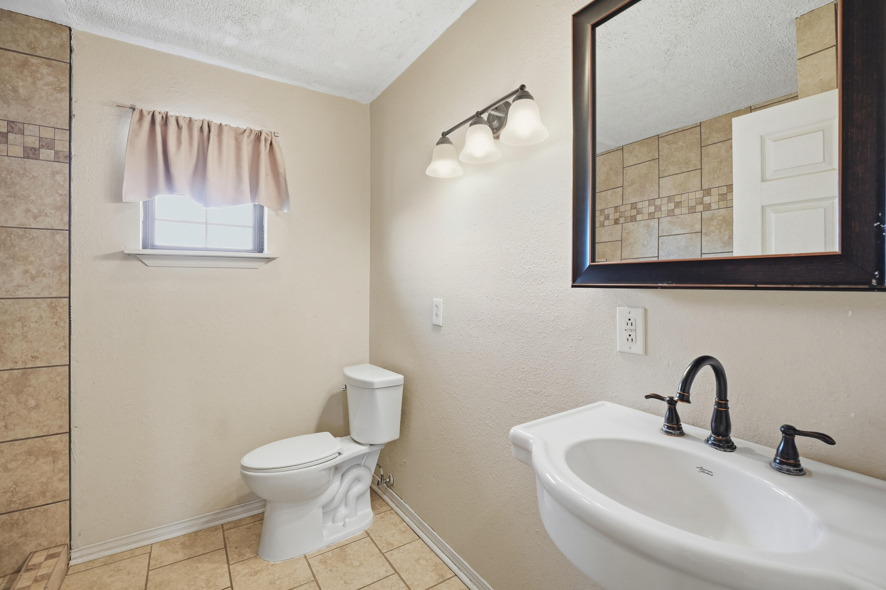 5601 County Road 7920 Lubbock, TX 79424 - Photo 57 of 68 a bathroom with a toilet sink and mirror