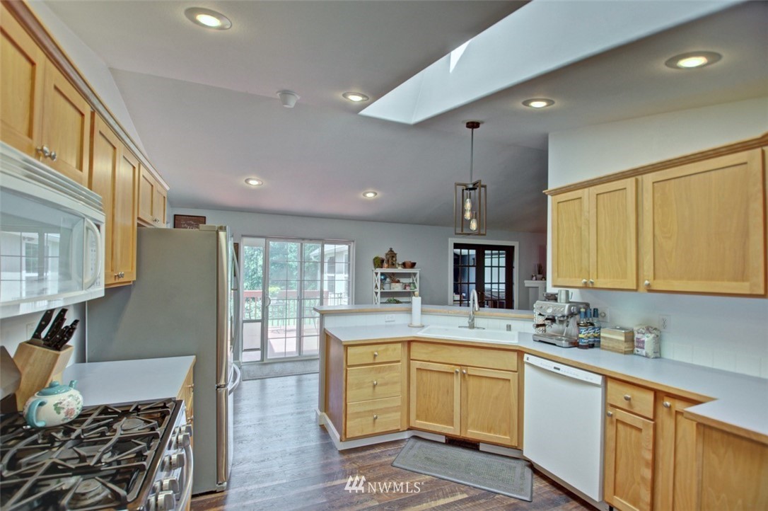 21741 Michigan Hill Road Southwest Rochester, WA 98579 - Photo 8 of 27 a kitchen with kitchen island granite countertop a sink stove and cabinets