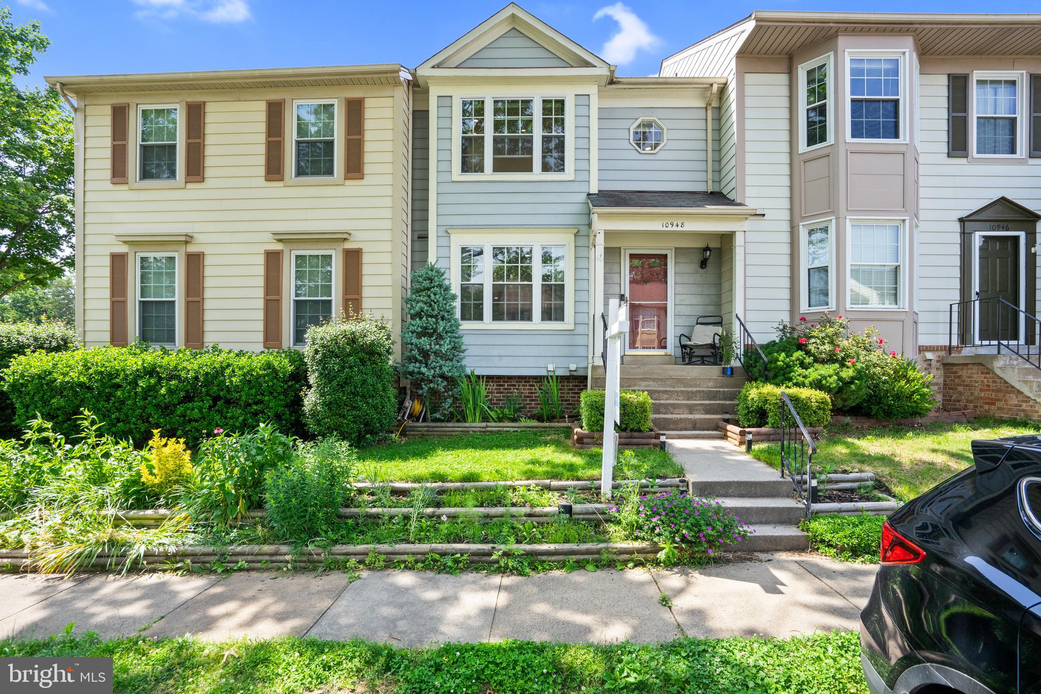 a front view of a house with a yard and potted plants