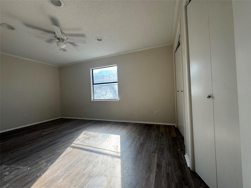 1421 South 12th Street, Unit 107 Waco, TX 76706 - Photo 13 of 25 an empty room with wooden floor fan and windows