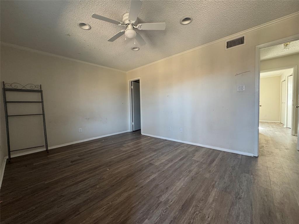 1421 South 12th Street, Unit 107 Waco, TX 76706 - Photo 14 of 25 an empty room with wooden floor chandelier fan and windows