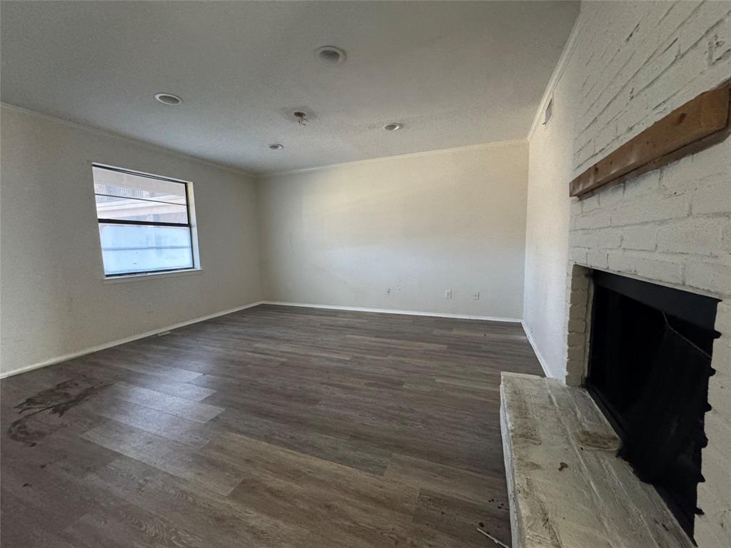 1421 South 12th Street, Unit 107 Waco, TX 76706 - Photo 3 of 25 an empty room with wooden floor fireplace and windows