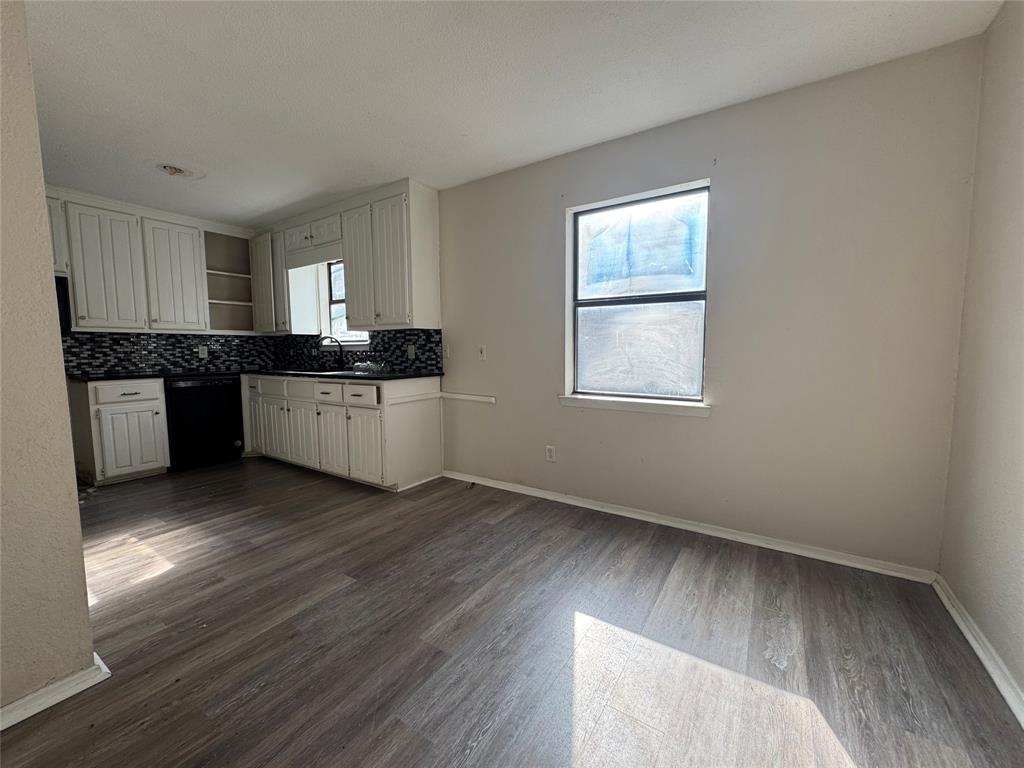 1421 South 12th Street, Unit 107 Waco, TX 76706 - Photo 6 of 25 an empty room with kitchen appliances wooden floor and a window