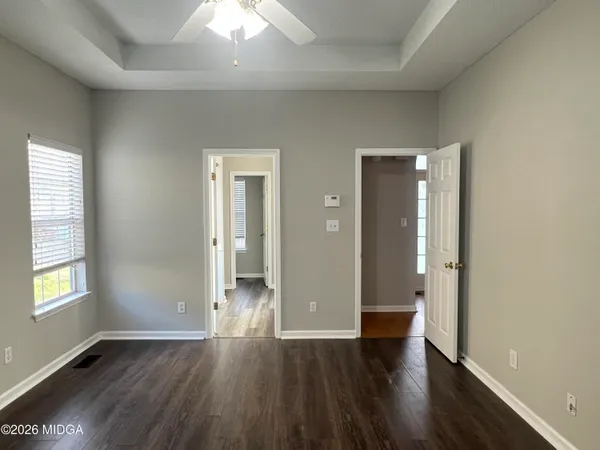 an empty room with wooden floor and windows