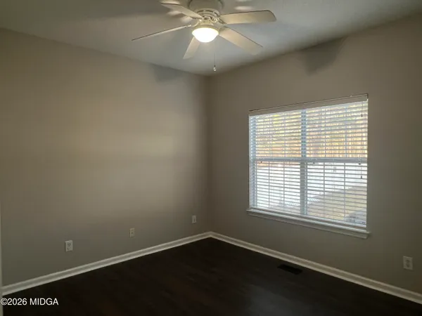 an empty room with a window and a fan