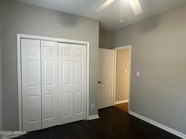 an empty room with wooden floor and closet area